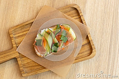 Appetizing bruschetta sandwich made from whole grain bread, with red fish and curd cheese, with thinly sliced â€‹â€‹cucumber. Stock Photo